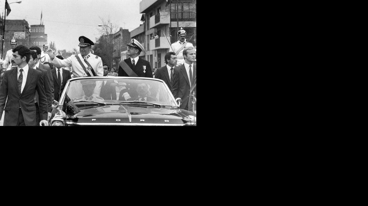 
El dictador Augusto Pinochet (izq.) durante un recorrido por Santiago de Chile en una foto de archivo sin fechar.


