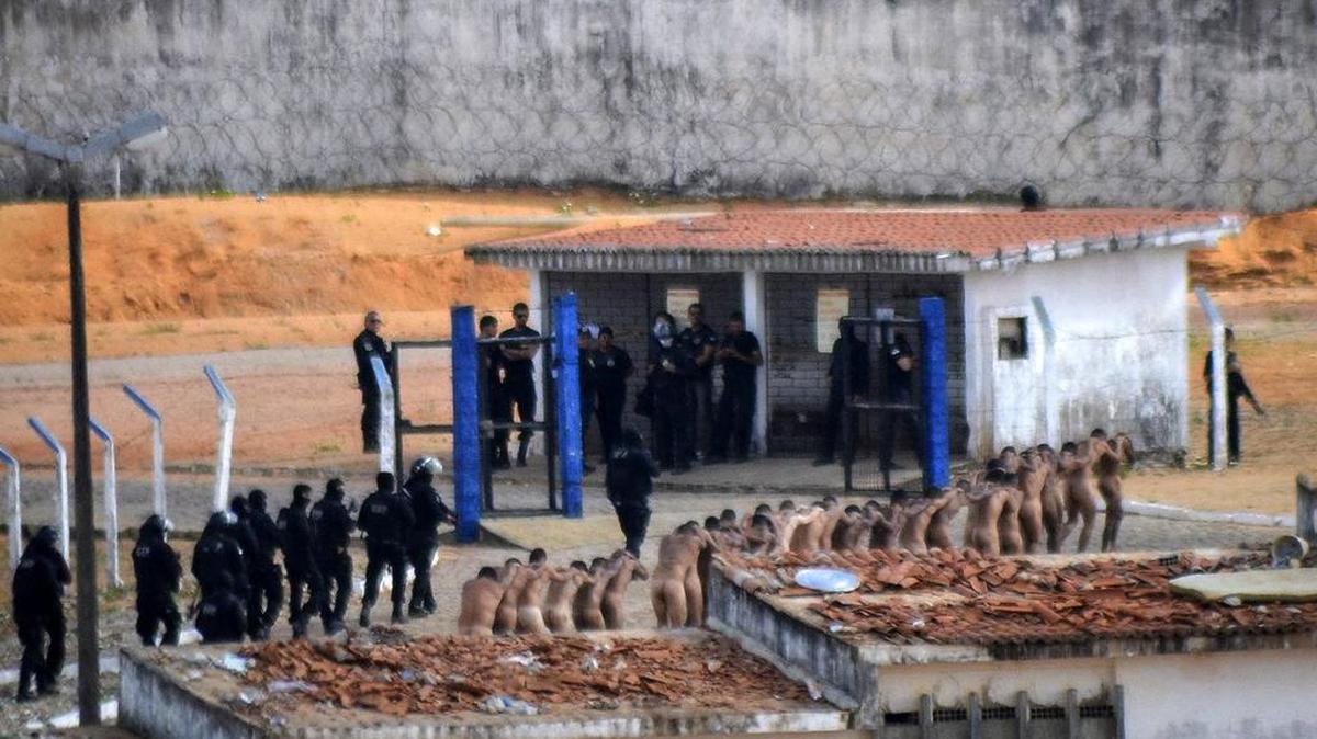 Un grupo de presos es custodiado por la Policía en la prisión de Alcaçuz, el domingo en la ciudad de Natal, Brasil.