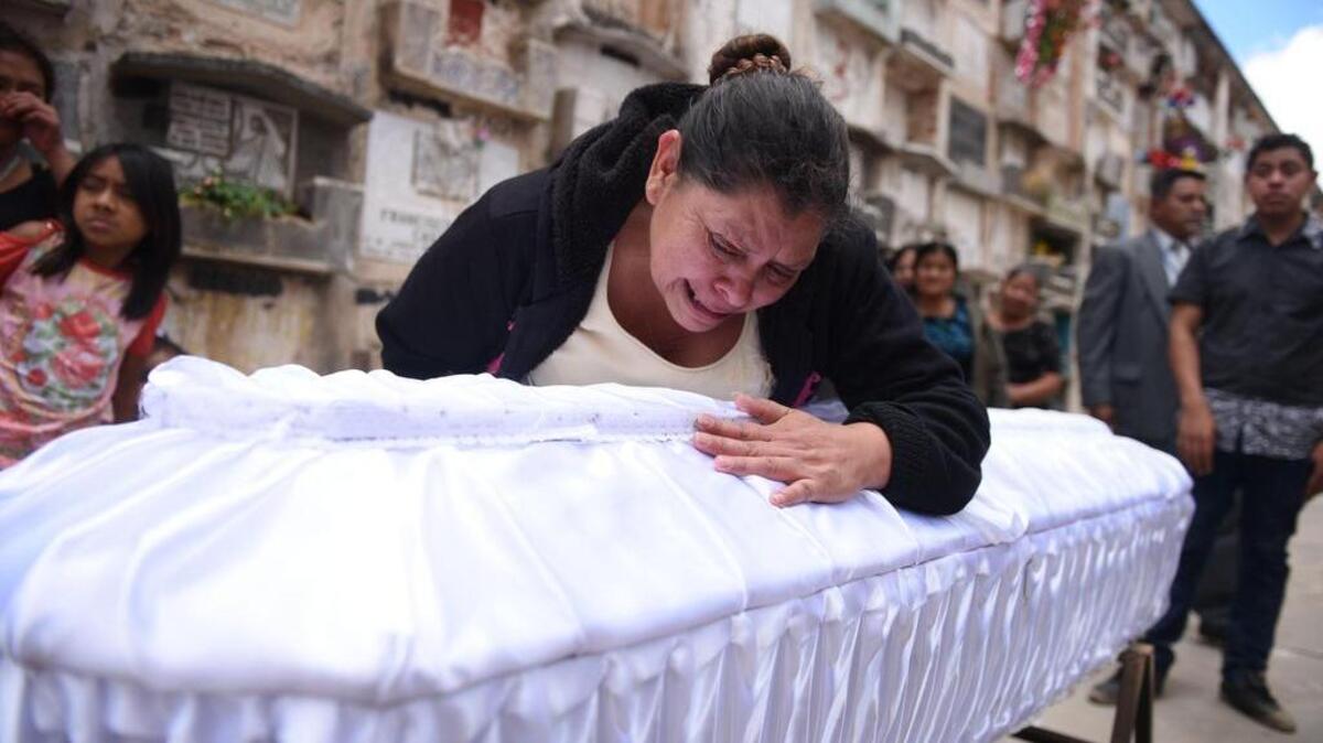 Rosa María Tobar (c), madre de la niña Rosa Espino Tobar, llora sobre el ataúd donde esta el cuerpo de su hija, la cual fue enterrada el 10 de marzo de 2017, en el Cementerio General de Guatemala (Guatemala). Espino fue una de las 37 víctimas mortales de un incendio en un refugio de menores del Estado en la capital guatemalteca tras una manifestación que realizaban las menores por supuestos abusos sexuales y físicos.