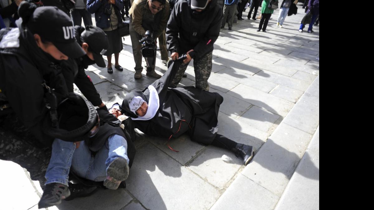 
Agentes policiales intentan retirar el lunes de la Catedral Metropolitana a dos integrantes de Mujeres Creando, quienes protestan el lunes contra la visita del Papa a Bolivia.
