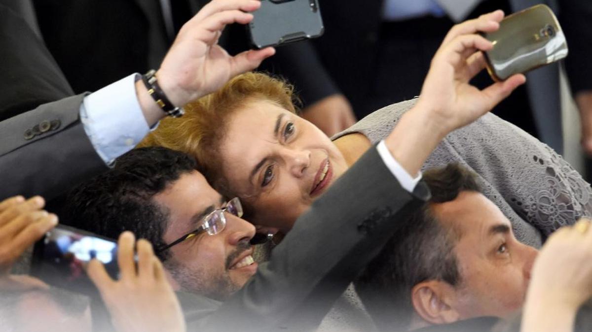 La presidenta de Brasil, Dilma Rousseff, posa el martes para tomarse “selfies”, tras una reunión con un grupo de abogados en el Palacio de Planalto, que le brindó su respaldo.