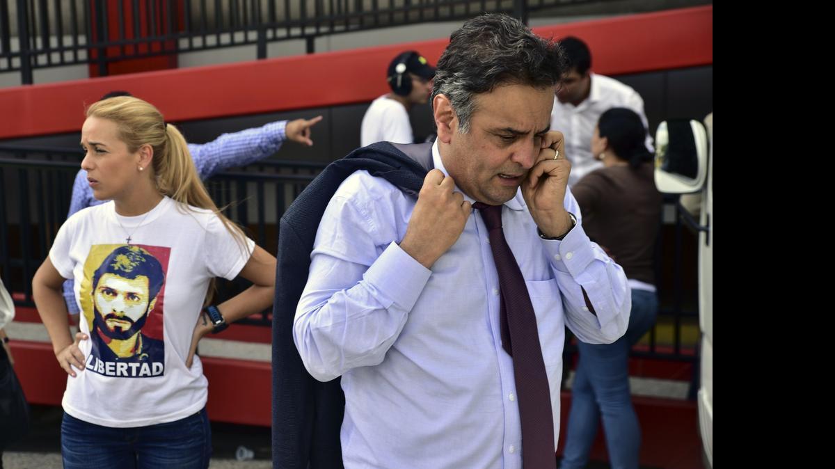 
El senador Aecio Neves habla por su celular tras su llegada al Aeropuerto Internacional de Maiquetía. Detrás Lilian Tintori, esposa del líder opositor preso Leopoldo López.
