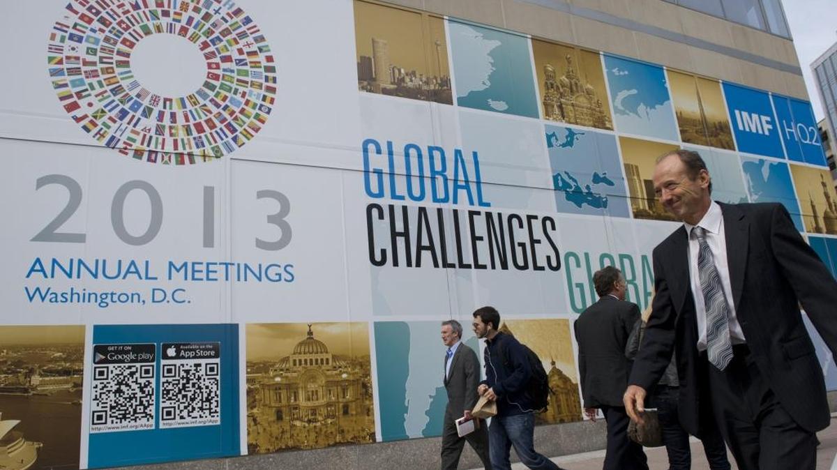 Personas caminan frente a la sede del Fondo Monetario Internacional, durante la reunión anual de ese organismo multilareral de financiamiento y del Banco Mundial, en el 2013.
