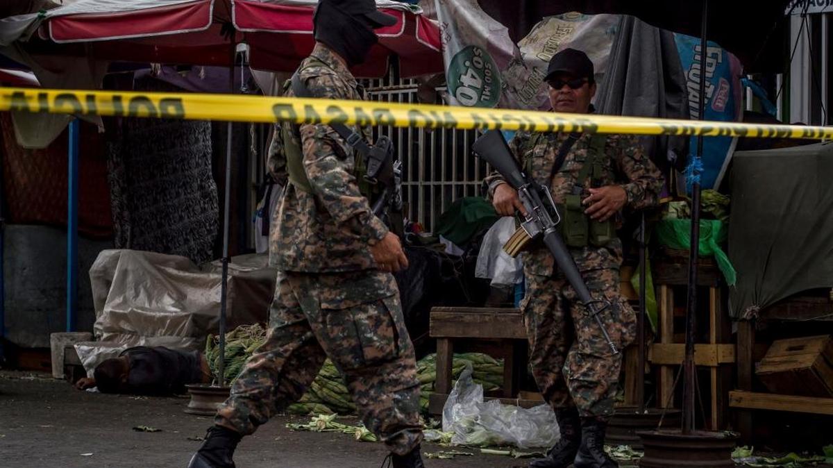 Soldados custodian el lugar de un tiroteo entre guardias de seguridad y pandilleros, en marzo del 2015 en El Salvador.