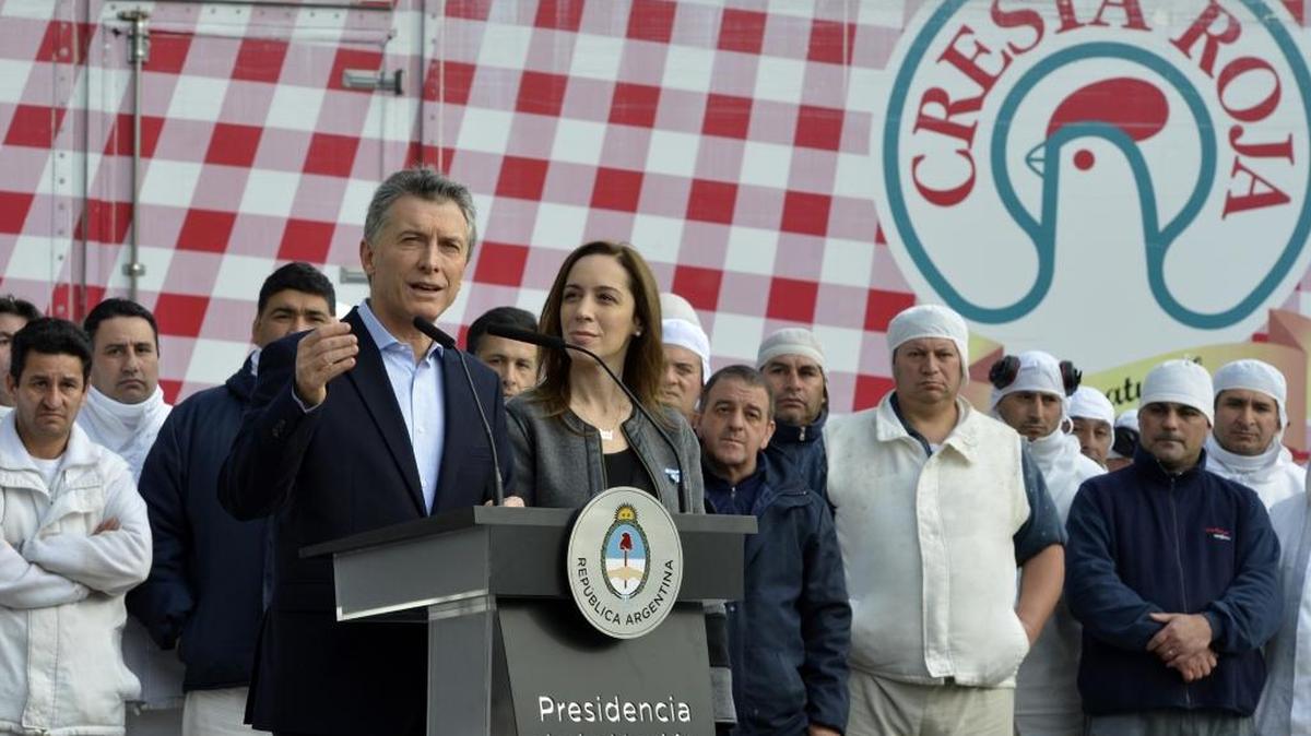 El presidente argentino, Mauricio Macri (izq.) en el momento que anuncia el veto a la ley anti despidos, junto a la gobernadora de Buenos Aires, María Eugenia Vidal, y trabajadores de una planta de pollos.