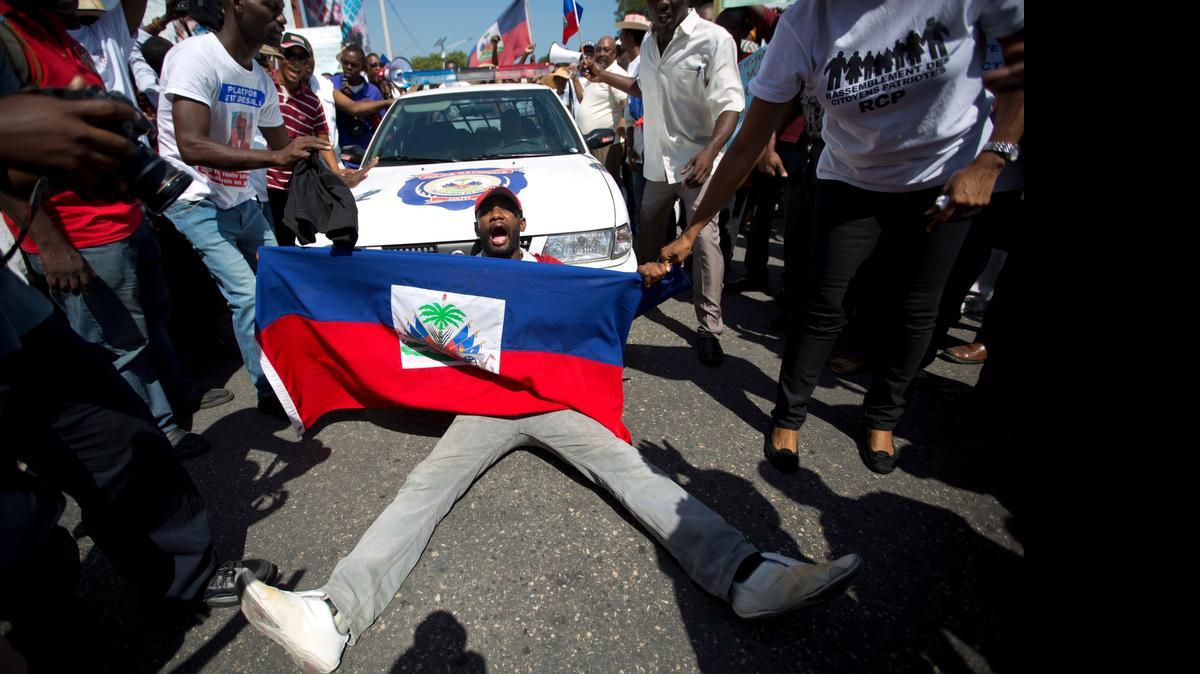 
Un manifestante grita ‘No al racismo’ cuando bloqueá una patrulla policial durante una protesta la semana pasada, en Puerto Príncipe, contra las deportaciones de haitianos desde R. Dominicana.

