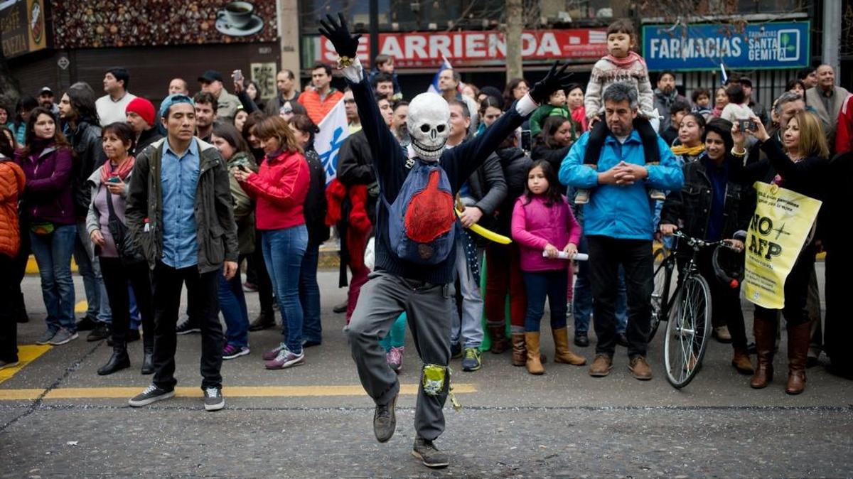Un hombre con una máscara marcha en protesta por un anticuado fondo de pensiones en Santiago, Chile.