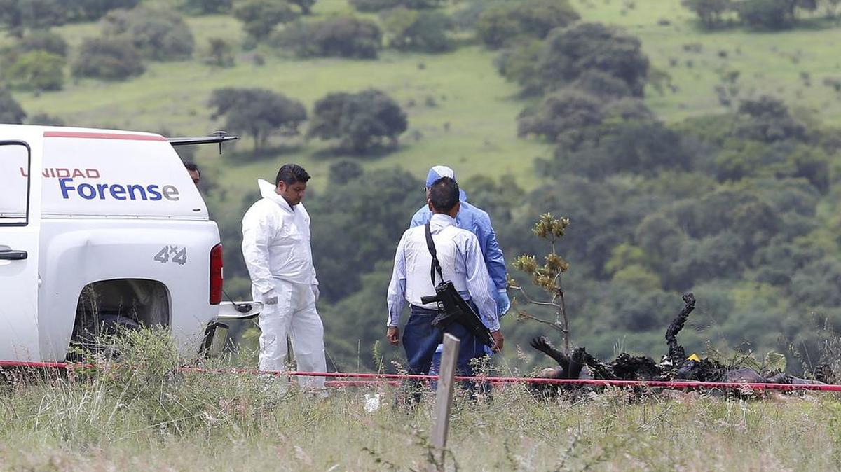 Médicos forenses levantan los cuerpos calcinados de varias personas en un predio de la localidad de Huehuetlán el Grande, en el estado de Puebla, el lunes 3 de julio de 2017.
