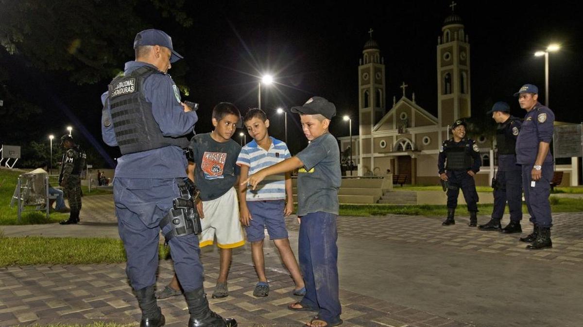 Policías hablan con niños en un parque de San Pedro Sula, Honduras, durante un patrullaje. La organización Casa Alianza denunció este domingo que en ese país existen escuadrones de exterminio e instó al gobierno a detener la “matanza” de niños y adolescentes.