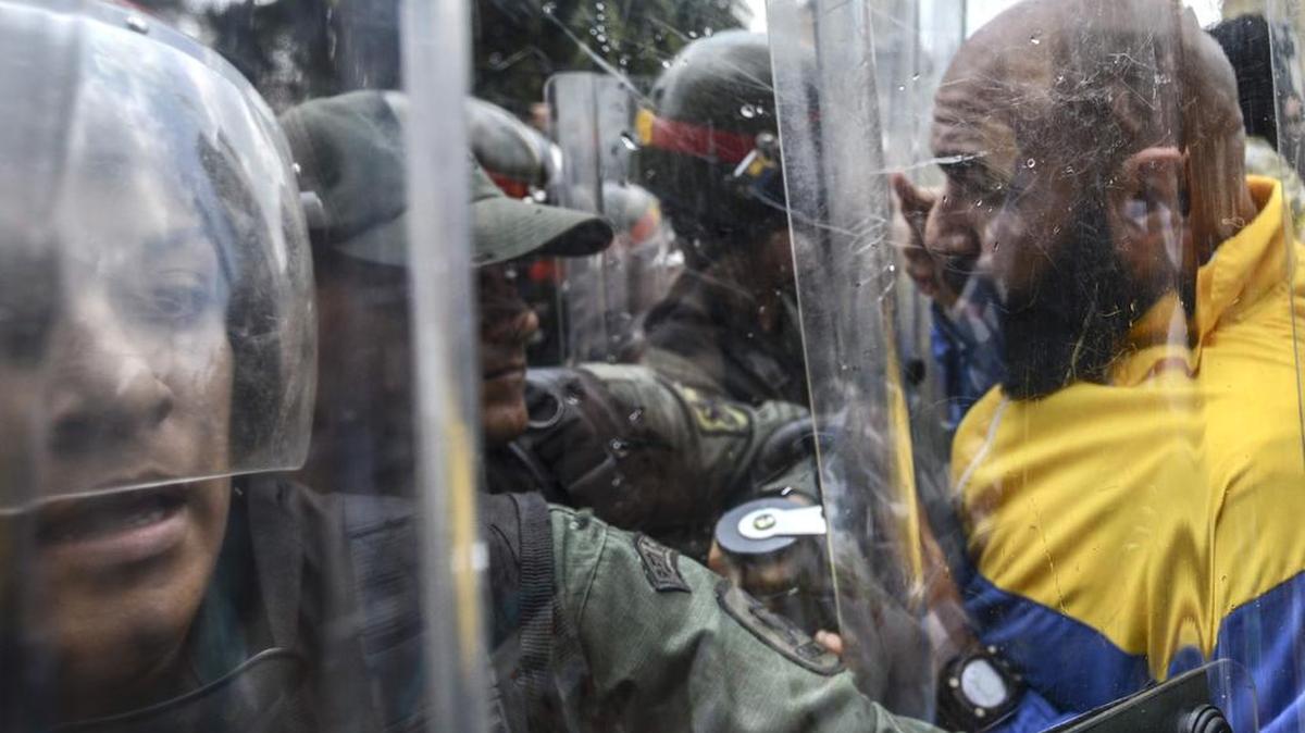 El diputado opositor Carlos Bozo se enfrenta a soladados de la Guardia Nacional el jueves cuando intentaba llegar junto a un grupo de dirigentes a la sede del Tribunal Supremo de Justicia de Venezuela, en Caracas.