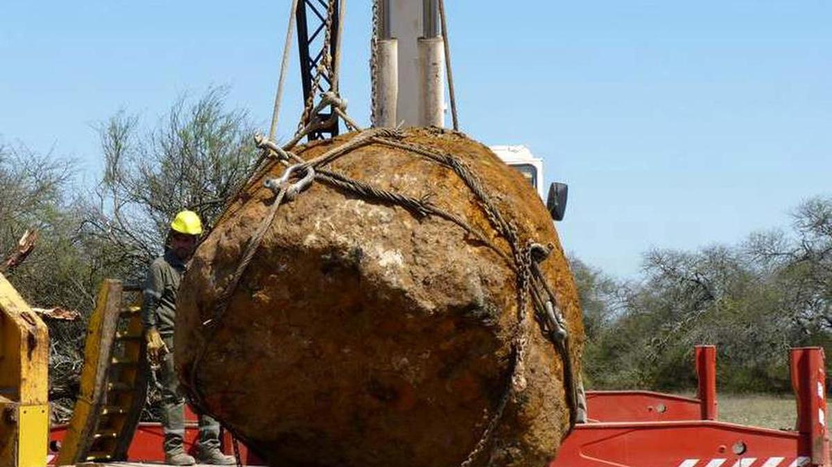 Fotografía del 12 de septiembre de 2016 cedida por el Diario Norte en la que se observa a un trabajador junto al segundo meteorito más grande del mundo, que fue descubierto y extraído en la zona de Charata en la provincia de Chaco (Argentina).