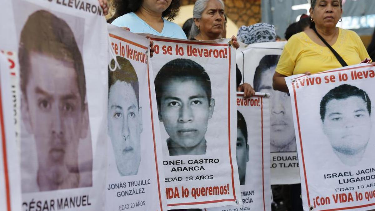 Estudiantes y padres de los 43 jóvenes desaparecidos de Ayotzinapa muestran carteles con los retratos de sus hijos durante el recibimiento a la relatora para México de la Comisión Interamericana de Derechos Humanos (CIDH), Esmeralda Arosemena, este lunes, a su llegada al municipio de Tixtla, en el estado de Guerrero (México).