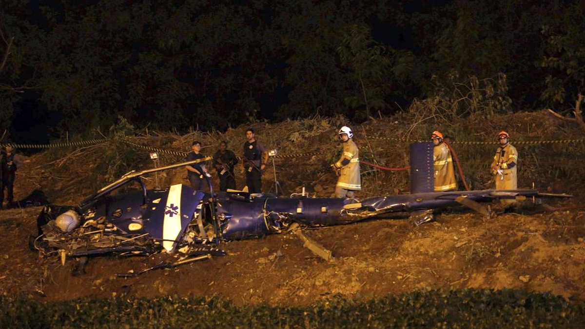Vista del helicóptero que cayó el sábado en un área próxima a la favela Cidade de Deus donde a lo largo del día se registraron fuertes tiroteos entre agentes de las Unidades de la Policía Pacificadora (UPP) y criminales. El helicóptero, perteneciente a la Policía Militar, intentó realizar un aterrizaje de emergencia, pero no consiguió y acabó estrellándose contra el suelo, lo que provocó la muerte de sus tripulantes. Las autoridades competentes también han barajado la posibilidad de que la aeronave haya sido abatida por los narcotraficantes de la zona y han iniciado una investigación para esclarecer los hechos.