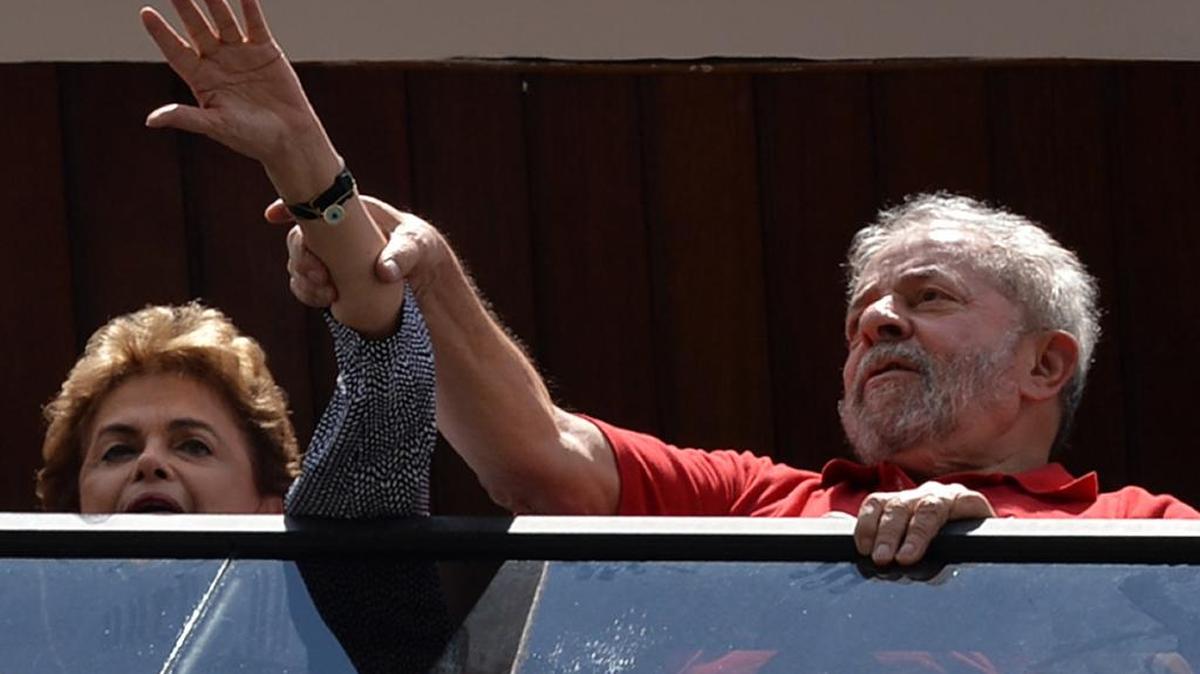 El ex presidente de Brasil, Luiz Inacio Lula da Silva (der.) y la actual presidente Dilma Rousseff saludan a partidarios reunidos fuera de su casa para mostrarle su apoyo, en Sao Bernardo do Campo, cerca de Sao Paulo, Brasil, el 5 de marzo de 2016.