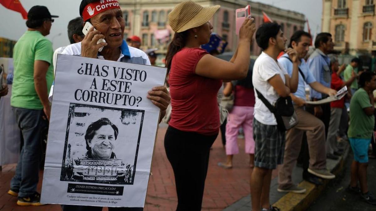 Un hombre sostiene un poster con la imagen del expresidente del Perú Alejandro Toledo con un mensaje que dice: "¿Has visto a este corrupto?", durante una marcha contra la corrupción en Lima, el 16 de febrero del 2017.