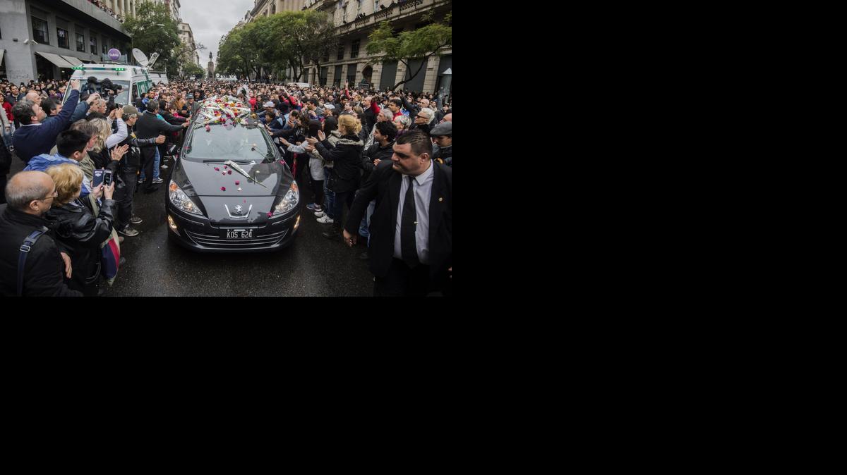 
Admiradores del fallecido cantante Gustavo Cerati saludan al paso del cortejo fúnebre, en Buenos Aires, Argentina.
