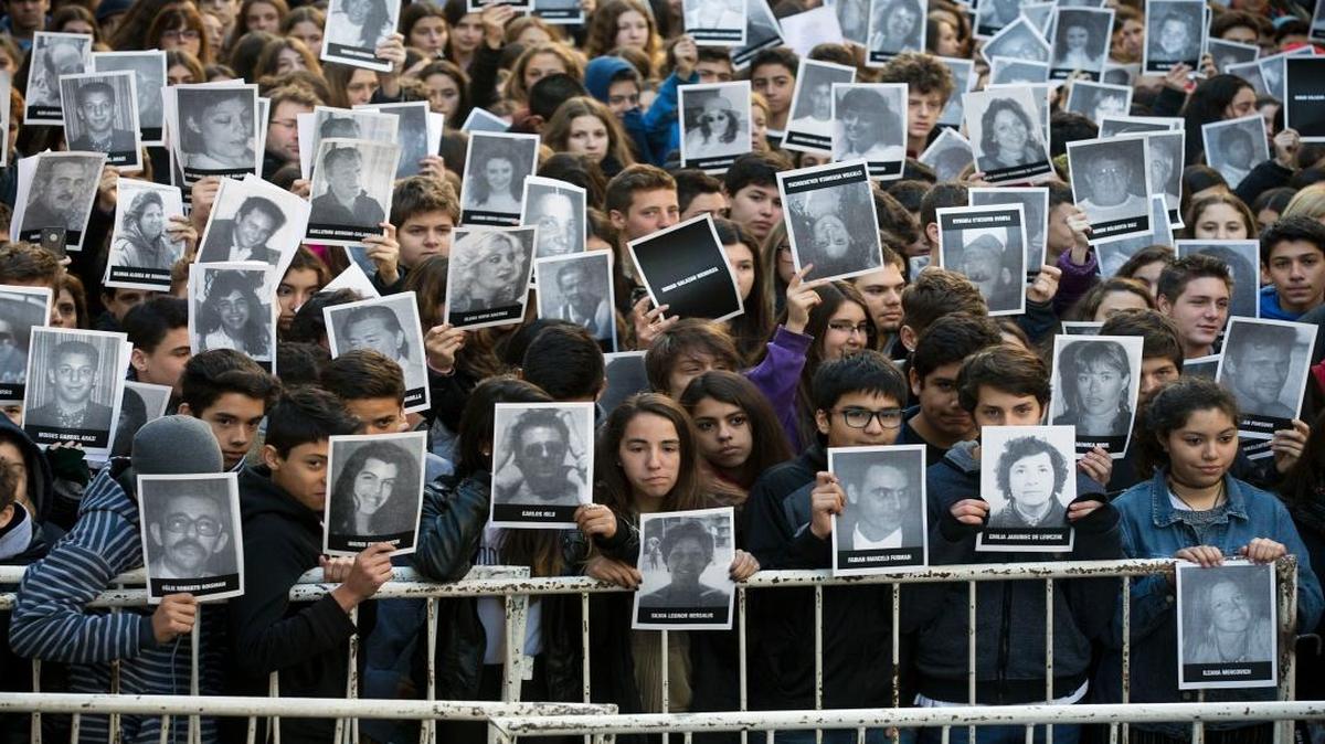La gente muestran fotos de las víctimas del bombardeo de 1994 del centro comunitario judío AMIA en el 21 aniversario del ataque terrorista en Buenos Aires, Argentina, el viernes 17 de julio de 2015. El bombardeo de la Asociación Mutual Argentino-Israelí en el centro de Buenos Aires Mató a 85 personas en 1994 y sigue sin resolver. Foto de archivo.