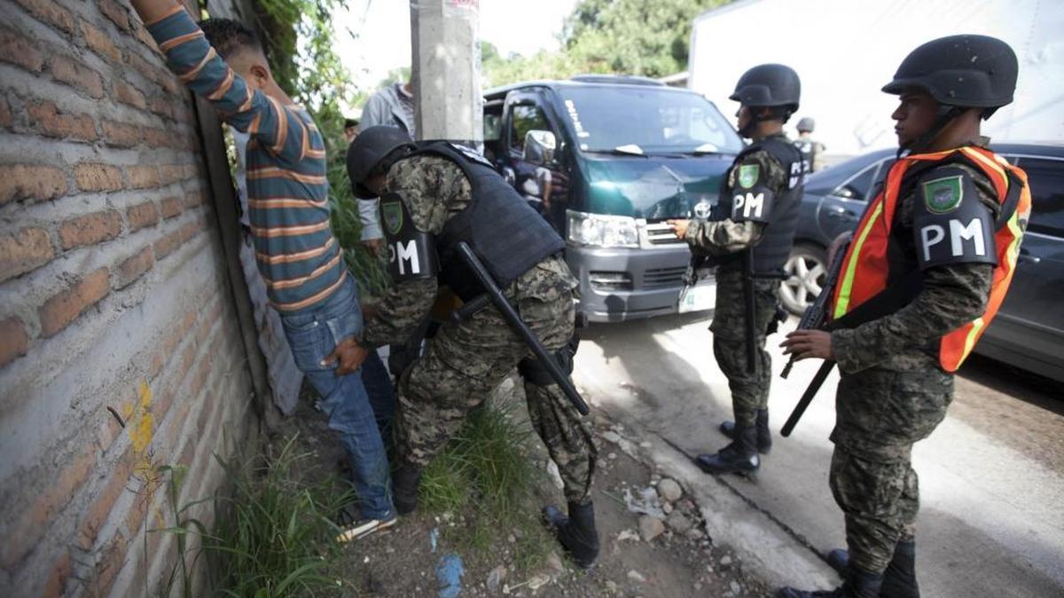 Miembros de la Policía Militar requisan a un hombre en el 2013, en la colonia La Pradera de Tegucigalpa, Honduras. La ciudad hondureña de San Pedro Sula es considerada como una de las más violentas de la región.