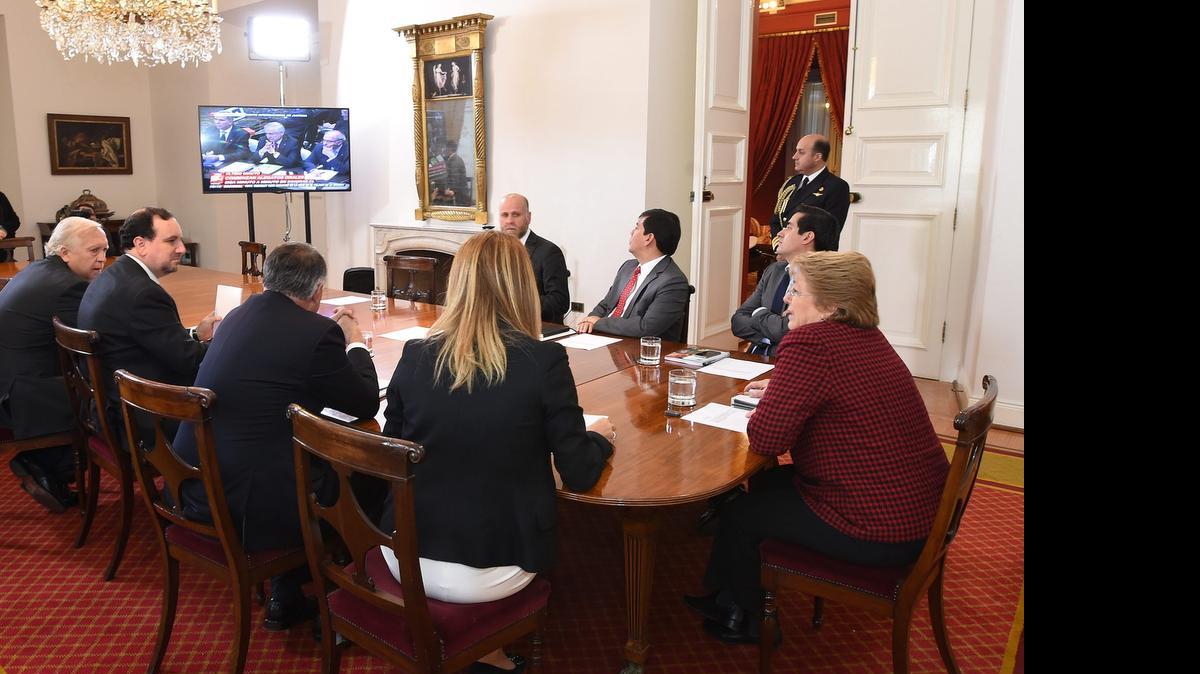 
La presidenta Michelle Bachelet (der.) junto a los ministros del Comité Político y funcionarios del ministerio de Relaciones Exteriores observan el lunesla transmisión de los alegatos de Chile ante la Corte Internacional de Justicia (CIJ) de La Haya, en el Palacio de La Moneda, en Santiago. 

