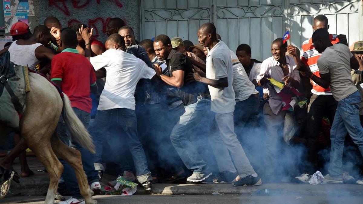 Seguidores de la Liga Alternativa por el Progreso y Emancipación Haitiana (LAPEH), huyen de una protesta luego de que la policía lanzara gases lagrimogenos. La manifestación se realizó en Puerto Príncipe en contra de los resultados electorales.