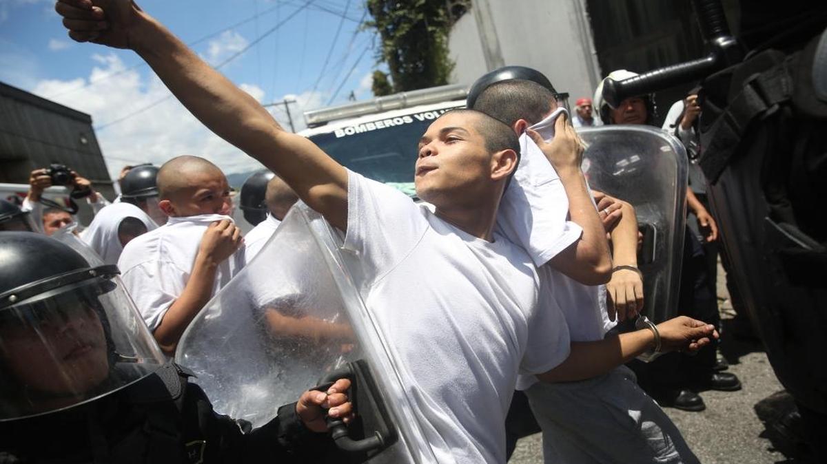 Agentes de policía detienen a un recluso que intentó huir de un centro correccional de menores el lunes 24 de julio de 2017, en Ciudad de Guatemala (Guatemala). Al menos 12 presos resultaron heridos en un nuevo motín en "Las Gaviotas", un centro correccional de Guatemala, informaron fuentes oficiales. El ministro de Gobernación (Interior), Francisco Rivas, explicó en una rueda de prensa que el motín se inició por una riña entre dos grupos de detenidos conocidos como "los paisas" y la "Mara Salvatrucha". Los cuerpos de socorro trasladaron a 12 presos heridos hacia dos hospitales públicos de la capital guatemalteca.