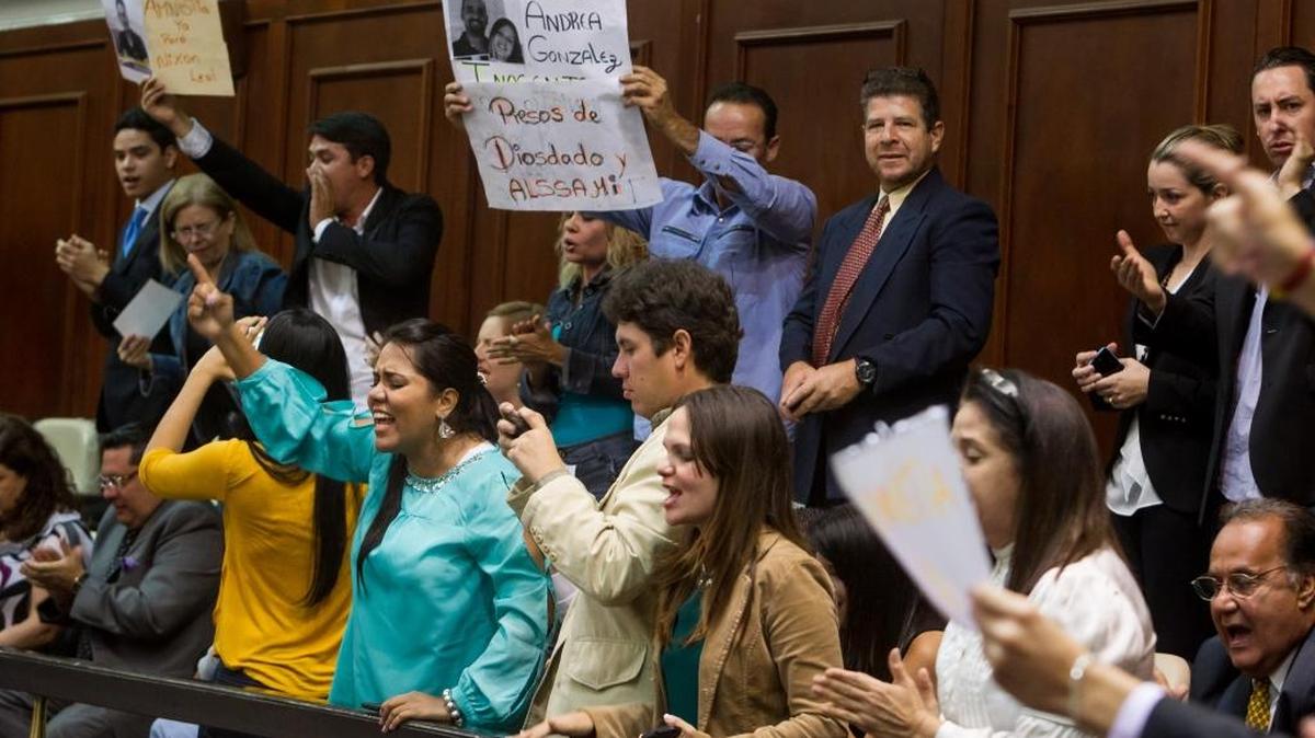 Familiares de presos políticos muestran afiches en el palco de invitados del hemiciclo de sesiones de la Asamblea Nacional el jueves.