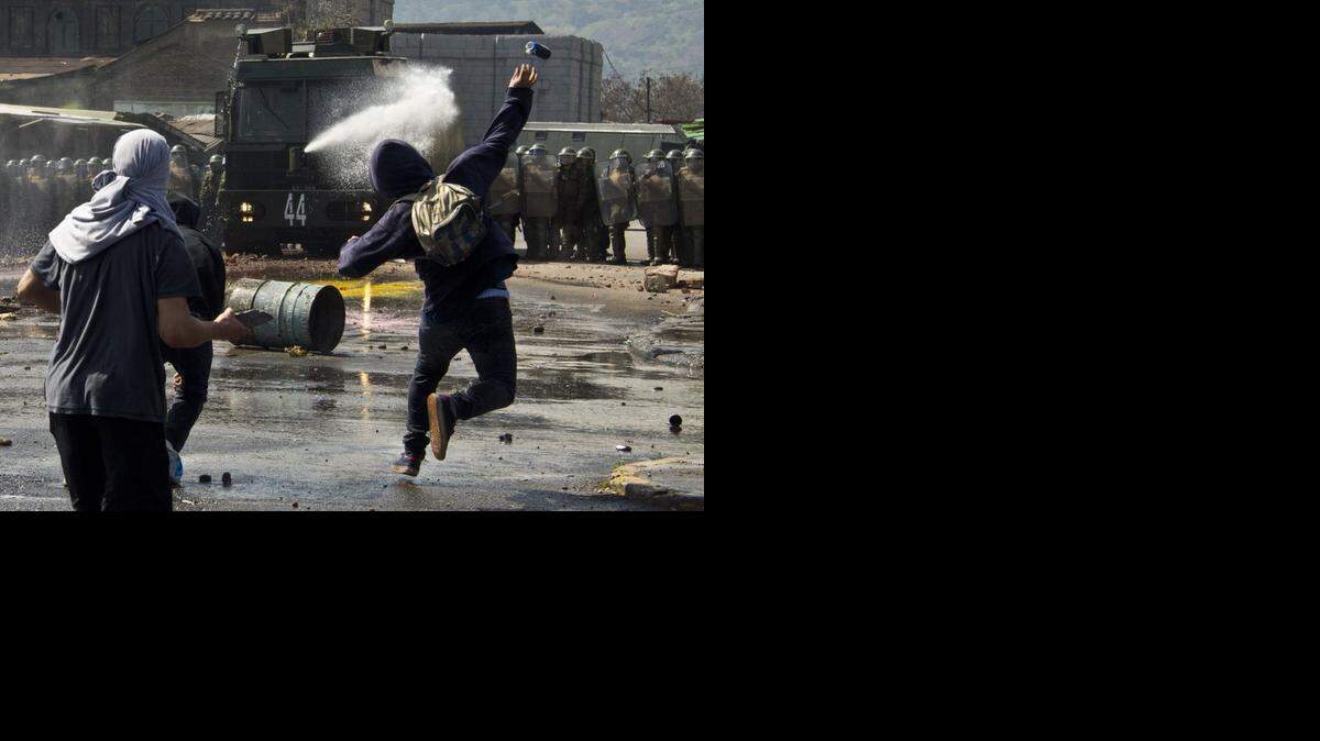 
Activistas de una organización de derechos humanos en Chile se enfrentan el domingo a los carabineros en Santiago como parte de las manifestaciones por el Golpe de Estado en 1973.


