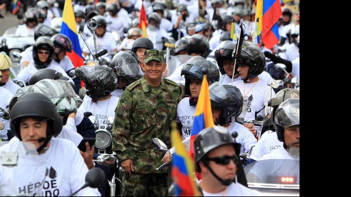 
El comandante del Ejército de Colombia, general Jaime Lasprilla (cen.), posa en medio de una caravana de motociclistas en honor a soldados y policías discapacitados por combates, el domingo en Bogotá
