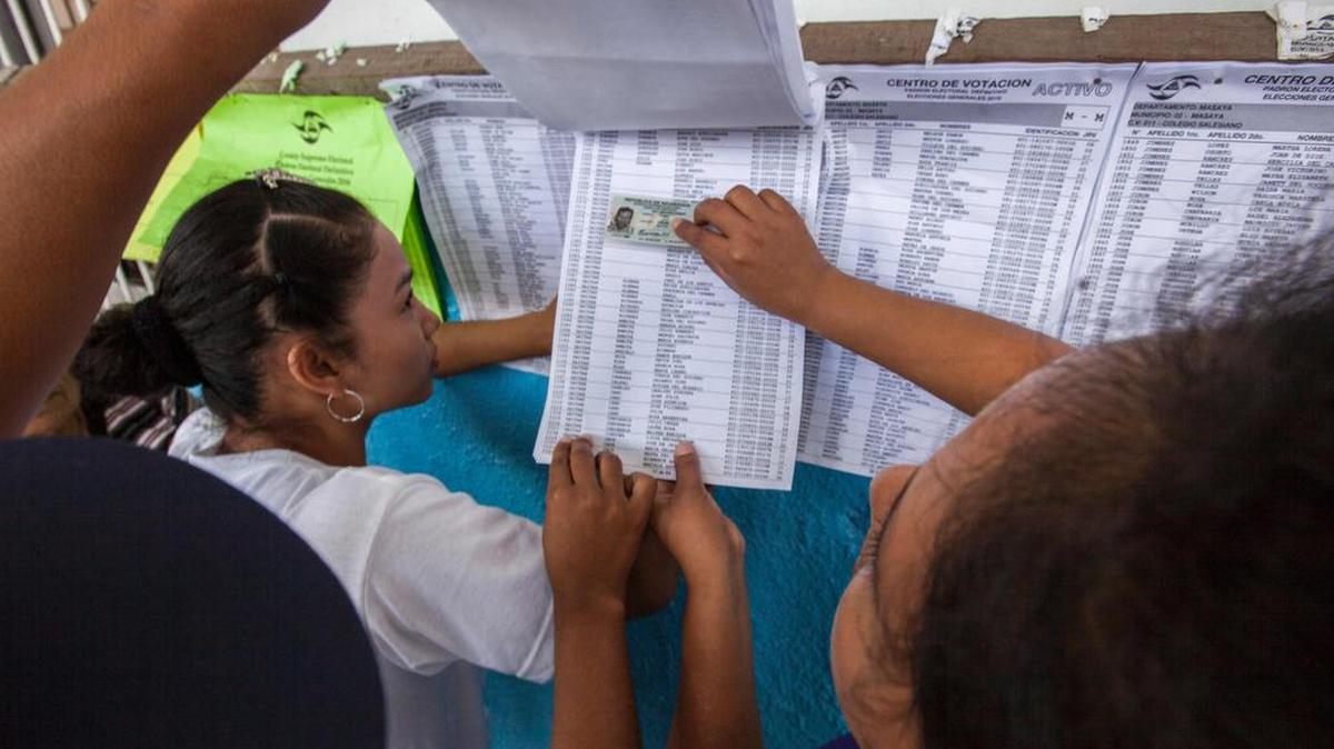 Nicaraguenses buscan sus nombres en una lista electoral en una mesa de votación en Managua durante la elección presidencial el 6 de noviembre de 2016.