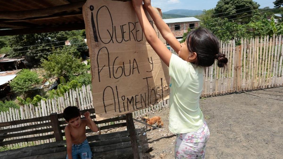 Una niña cuelga el miércoles un cartel en el que se señala “Queremos agua y alimentos”, en una casa en Montecristi, Ecuador.