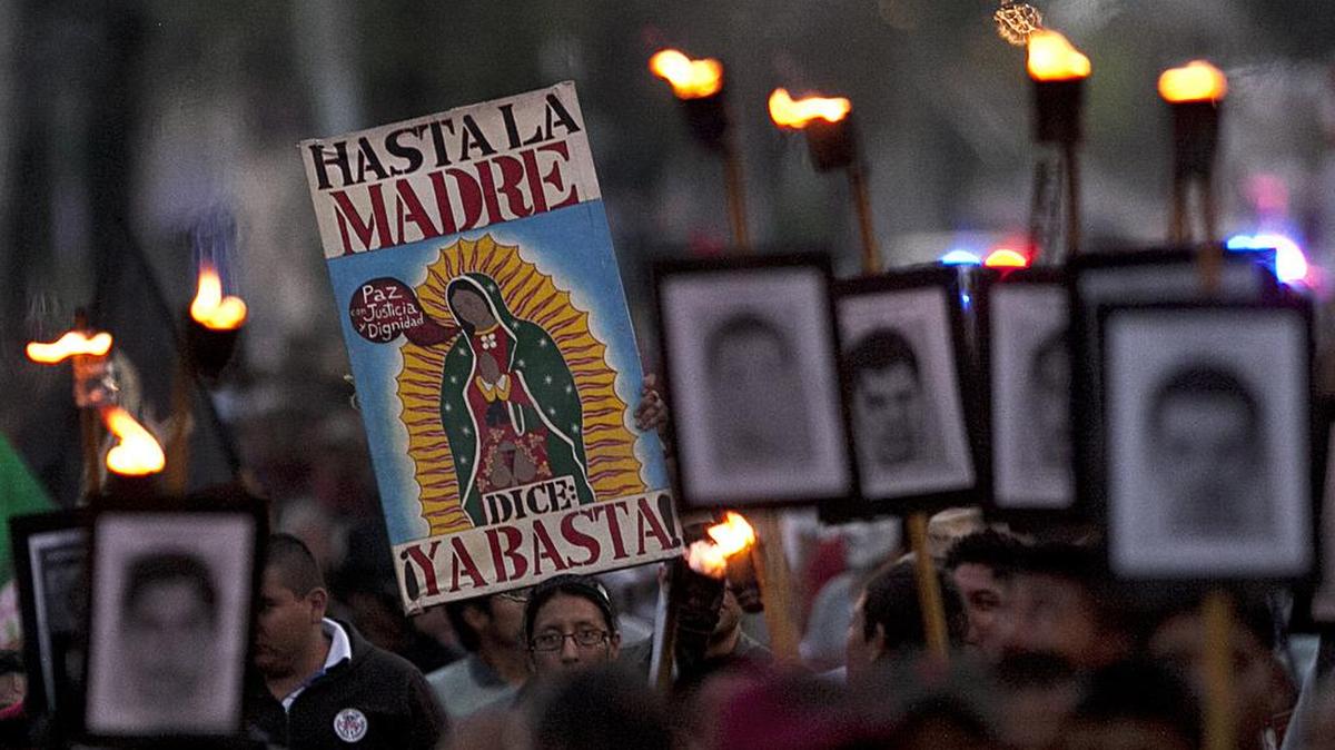 Los familiares de los 43 estudiantes desaparecidos marchan sosteniendo fotografías de sus seres queridos desaparecidos durante una protesta en la ciudad de México, el sábado, 26 de diciembre de 2015.