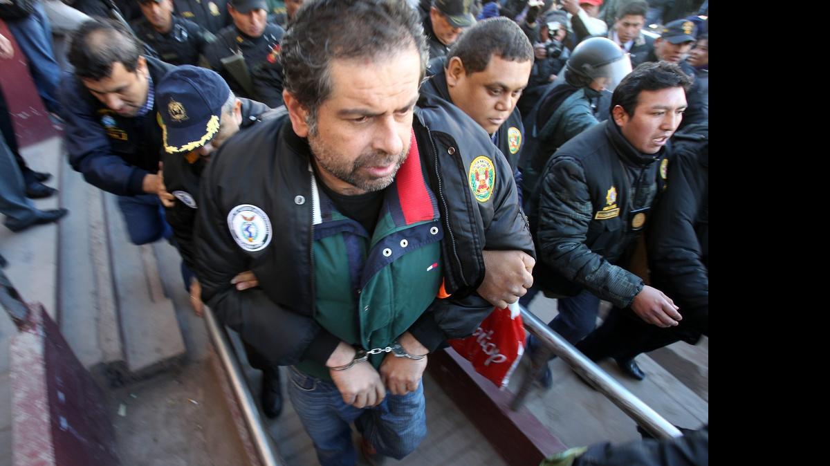 
Policías peruanos escoltan al empresario peruano Martín Belaunde Lossioel viernes, luego de su entrega por parte de las autoridades bolivianas en el puente internacional de Desaguadero, localidad fronteriza entre Bolivia y Perú. 
