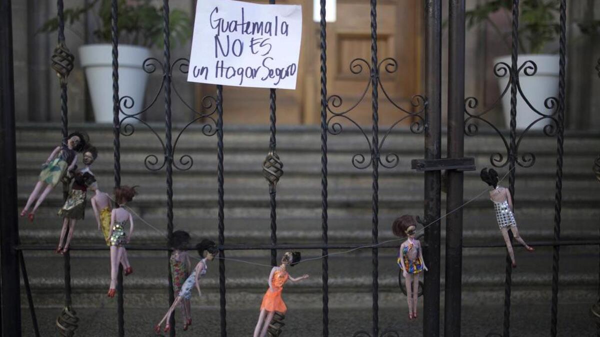 Una señal que dice “Guatemala no es un hogar seguro” cuelga de la puerta delantera de la casa presidencial en memoria de las víctimas de un incendio en un albergue para niños, en Ciudad de Guatemala, jueves, 9 de marzo de 2017.