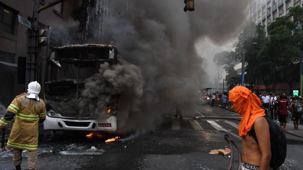 Funcionarios civiles que protestaban contra medidas de austeridad chocaron con la policía e incendiaron un autobús en la principal avenida de Río de Janeiro este miércoles.