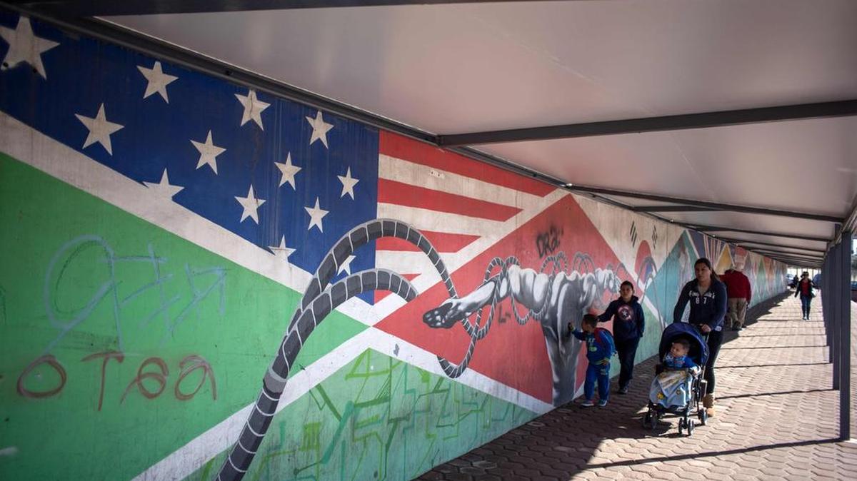 Gente camina en el paso peatonal de Otay, en el lado mexicano de la frontera entre Estados Unidos y México, el 25 de enero de 2017, en las afueras de Tijuana, al noroeste de México.