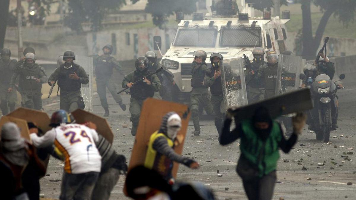 Agentes de la Guardia Nacional Bolivariana persiguen a manifestantes en Caracas, Venezuela, el viernes 28 de julio de 2017.