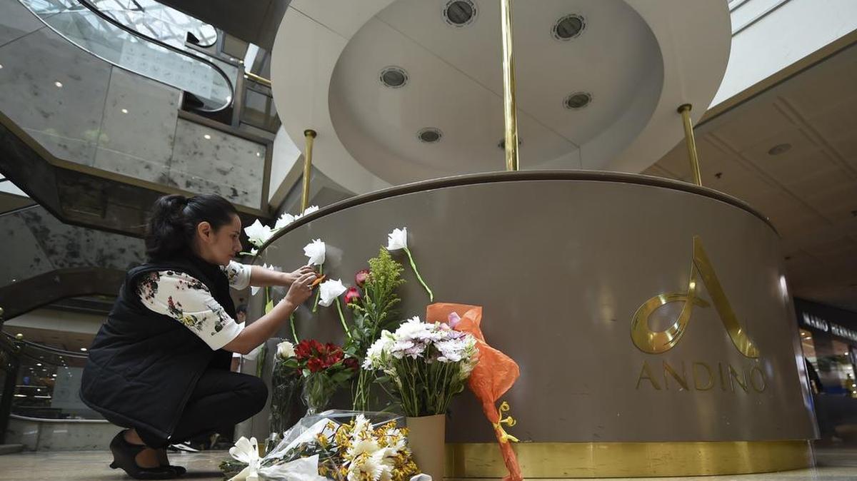 Una señora coloca flores en el centro comercial de Bogotá, donde una bomba explotó el pasado 8 de junio del 2017.