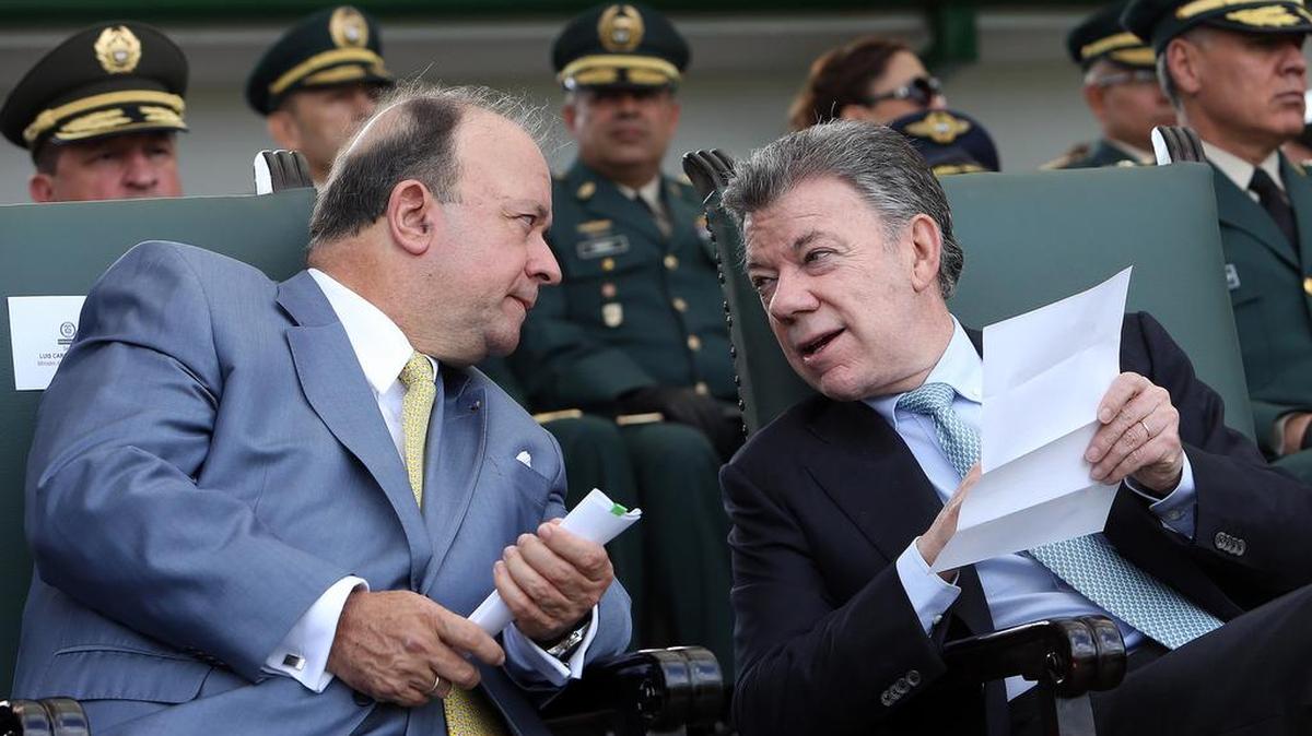 El presidente de Colombia, Juan Manuel Santos (d), habla con el ministros de Defensa, Luis Carlos Villegas (i), este sábado 19 de diciembre de 2015 en Bogotá (Colombia), durante una ceremonia de ascensos militares.