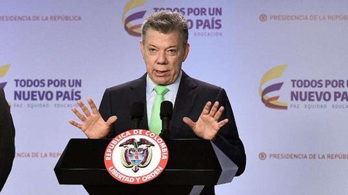 Fotografía cedida por la oficina de prensa de la Presidencia de Colombia, del mandatario, Juan Manuel Santos (d), junto al ministro del interior, Guillermo Rivera, durante una declaración el jueves 12 de octubre de 2017, en Bogotá (Colombia).