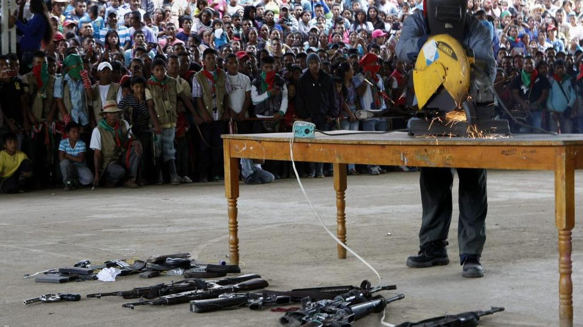 Miembros de la guardia indígena destruyen el domingo 11 de noviembre de 2014, armas, uniformes camuflados y una valla pertenecientes a los guerrilleros de las FARC que asesinaron el pasado miércoles a dos guardias indígenas en una vereda de Toribio, Cauca (Colombia).