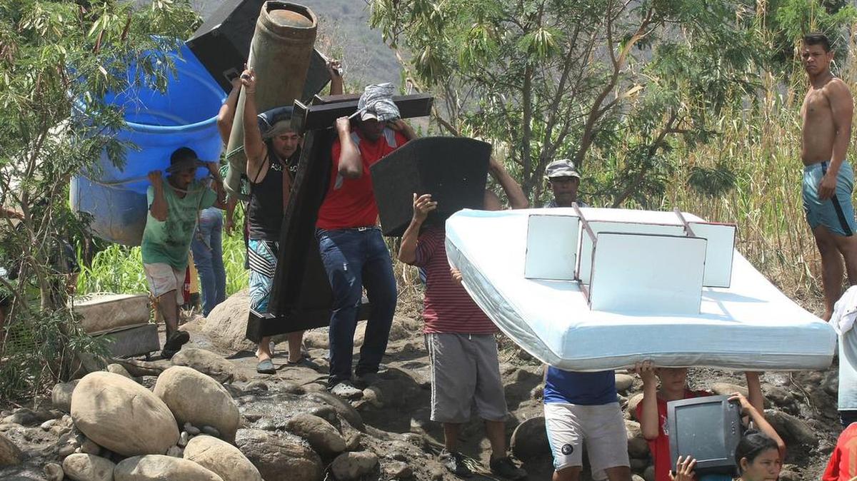 Colombianos cruzan el río Táchira, cerca de San Antonio del Táchira, Venezuela, en camino a Colombia, en agosto de 2015.