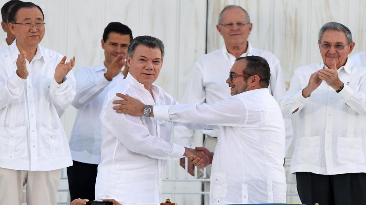 El presidente colombiano Juan Manuel Santos (centro a la izquierda) y el jefe de las FARC, Timoleón Jiménez, se saludan durante la firma del acuerdo de paz el 26 de septiembre.