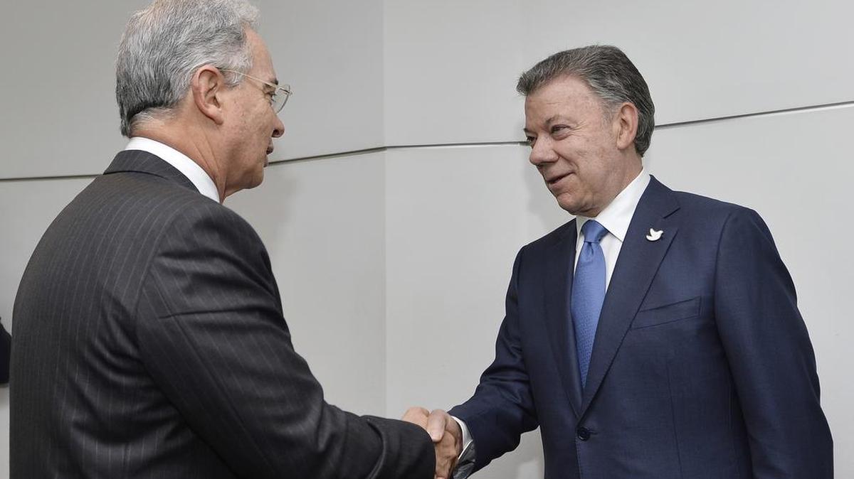 En esta foto difundida por la oficina de prensa de la presidencia de Colombia , el senador y ex presidente Alvaro Uribe, izquierda, estrecha la mano con el actual presidente Juan Manuel Santos, en el palacio presidencial en Bogotá, Colombia, miércoles, 5 de octubre de 2016.