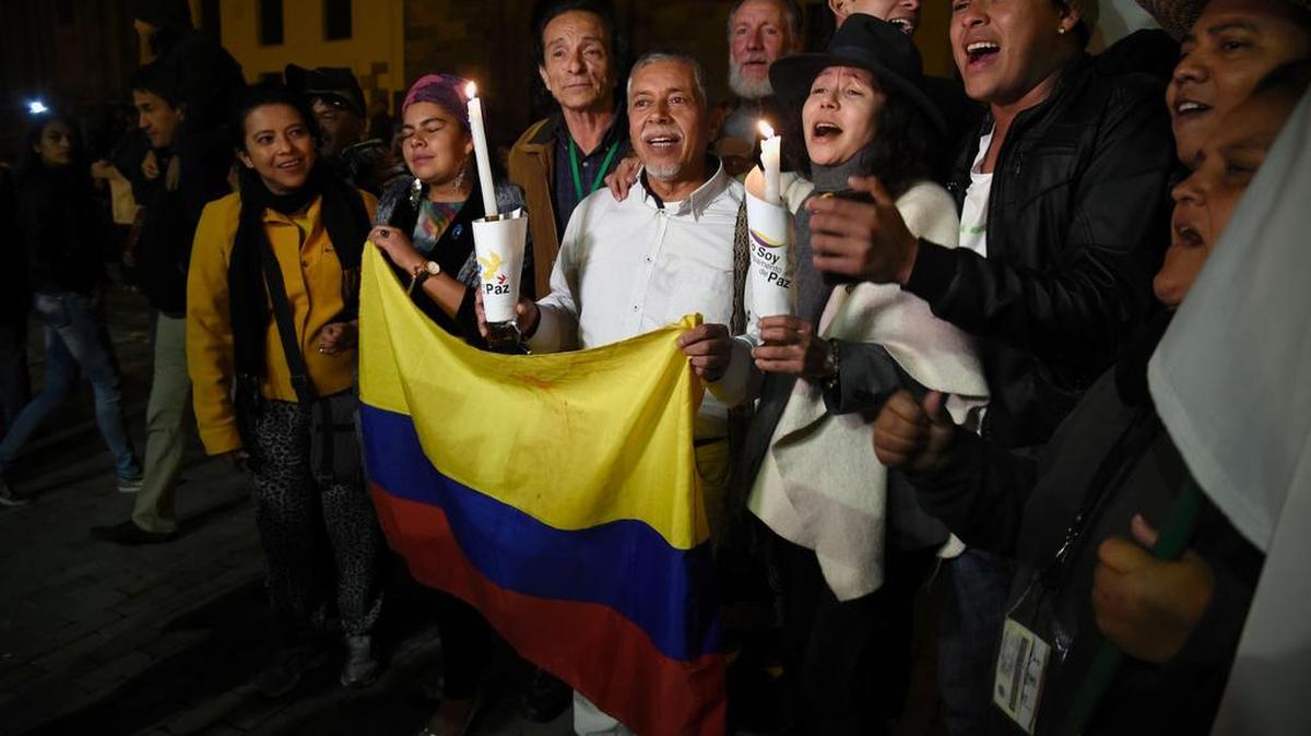 La gente celebra en la plaza principal de Bogotá, el 12 de noviembre de 2016, después de que el gobierno colombiano y los rebeldes marxistas FARC firmaran un nuevo y revisado acuerdo de paz para poner fin a 52 años de guerra civil.
