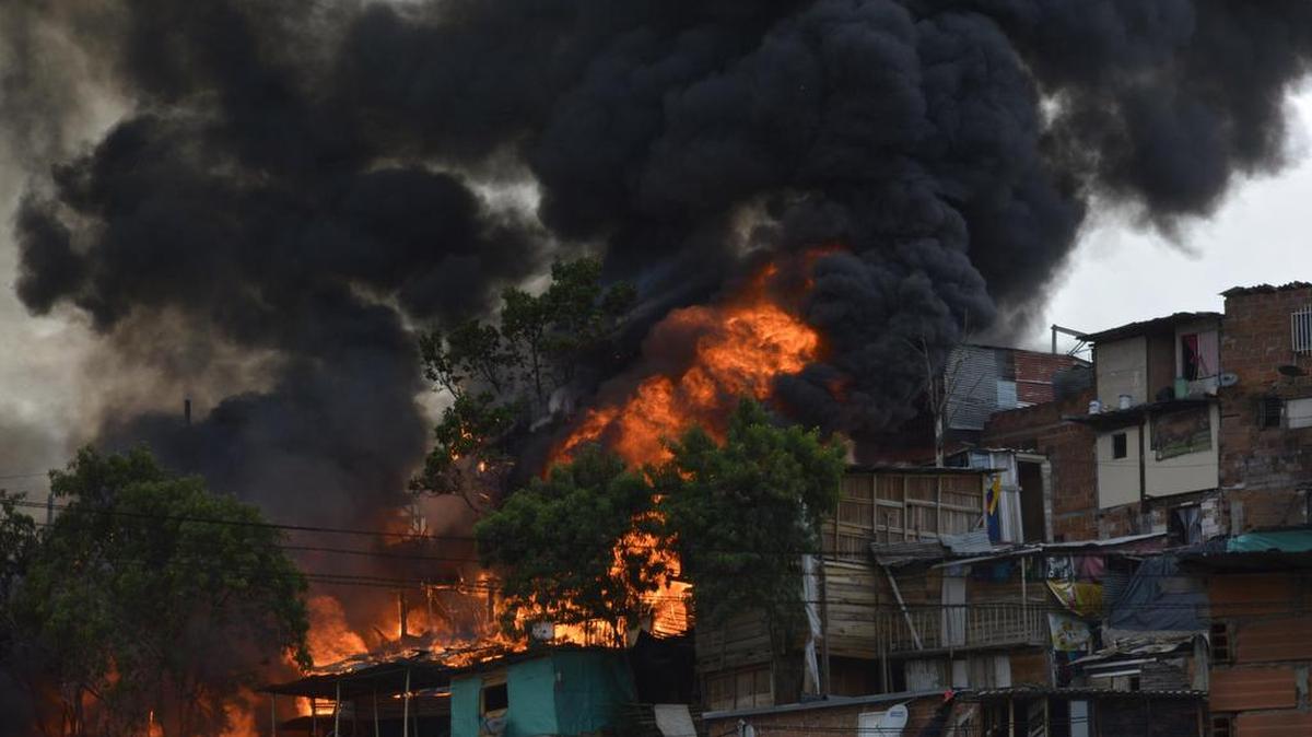 Vista general de un incendio el viernes 18 de agosto de 2107, en el barrio Moravia de Medellín (Colombia). Al menos nueve heridos dejó un incendio que consumió humildes casas de madera, y requirió la movilización de 11 máquinas de bomberos y unos 76 hombres, informó el alcalde de la ciudad colombiana, Federico Gutiérrez.