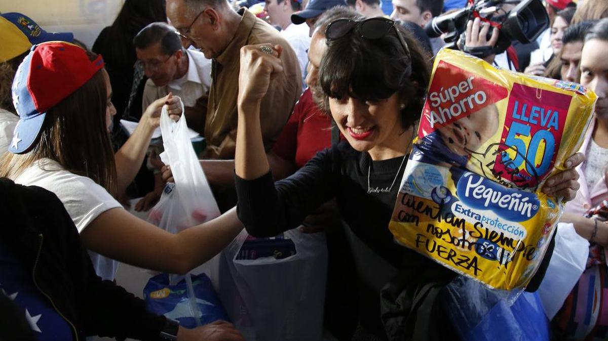 Una mujer entrega pañales durante una jornada de donación de medicinas y otros productos para Venezuela, realizada el jueves en Bogotá, Colombia.