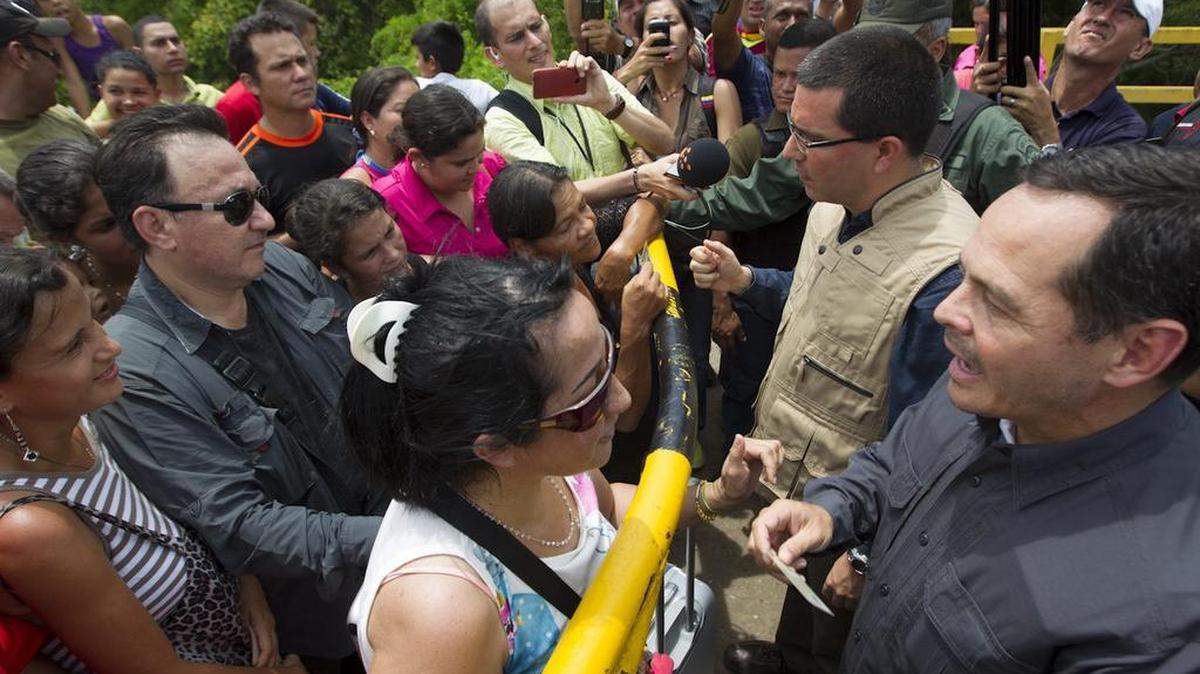 
Fotografía cedida por prensa de la Vicepresidencia de Venezuela, del gobernador del estado Tachira José Gregorio Vielma Mora (d) y el vicepresidente venezolano, Jorge Arreaza (2-d), que hablan con un grupo de personas que esperan para cruzar el puente internacional "La Union" hoy, sábado 29 de agosto de 2015, en la localidad de La Fria (Venezuela). El estado de excepción que el presidente de Venezuela, Nicolás Maduro, amplió ayer a cuatro municipios fronterizos provocó hoy otro éxodo de colombianos que, atemorizados ante la posibilidad de ser deportados, regresan a su país a través de rutas alternativas.
