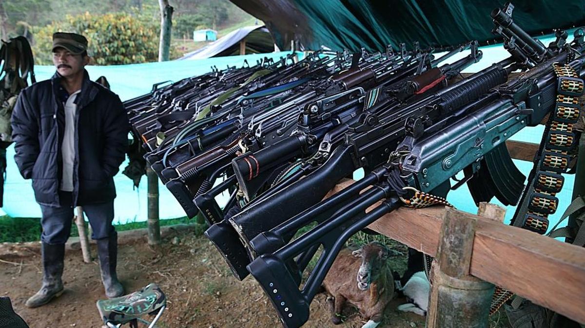 Un miembro de las FARC cuida varios rifles en la "Zona Veredal Transitoria de Normalización" La Lima, en el Departamento de Tolima, en febrero del 2017.
