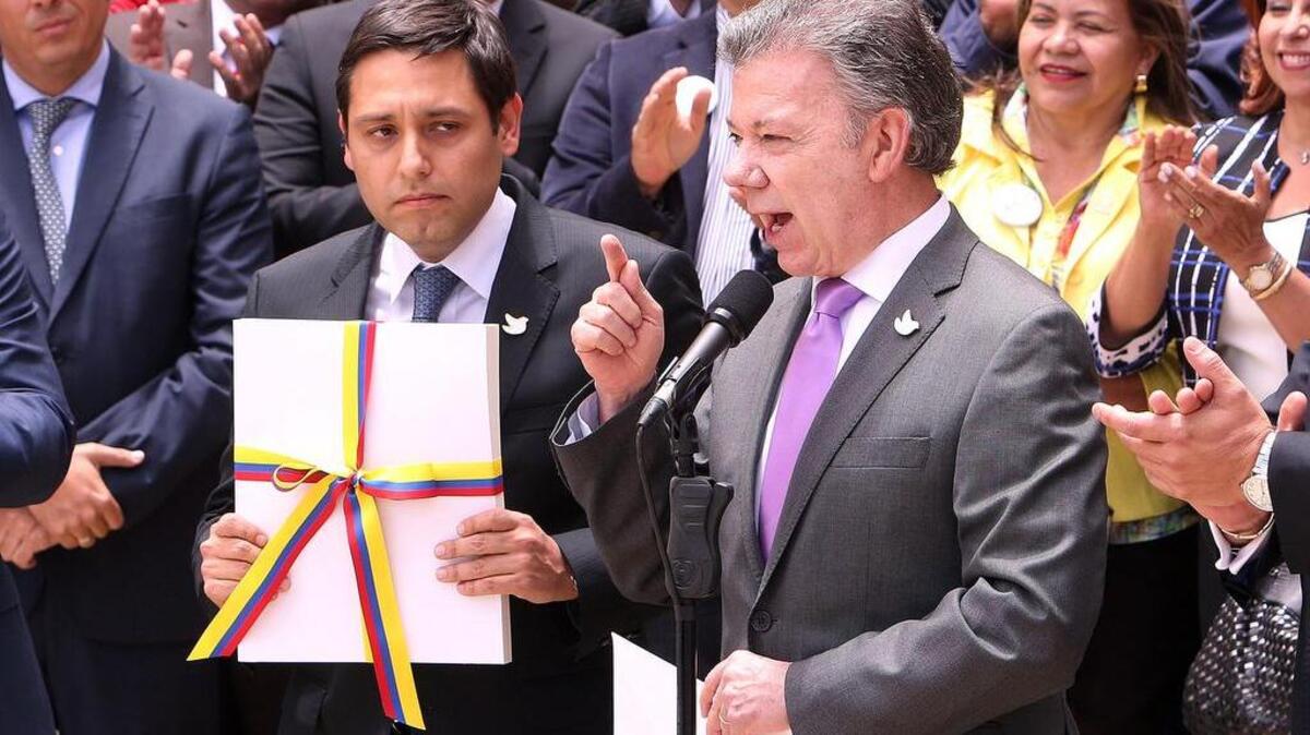 El Presidente de Colombia, Juan Manuel Santos (d), entrega al presidente del Congreso de Colombia, Mauricio Lizcano (c), el texto definitivo del acuerdo de paz con la guerrilla de las FARC, como paso previo para la convocatoria del plebiscito del 2 de octubre, en el que los ciudadanos decidirán si lo aprueban o no, el jueves 25 de Agosto de 2016, en Bogotá (Colombia).