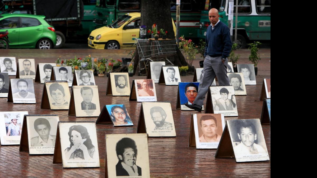 
Retratos de desaparecidos son observados por peatones en el 2012, durante su exhibición en la Plaza de Lourdes, durante la conmemoración del Día Internacional del Desaparecido, en Bogotá.
